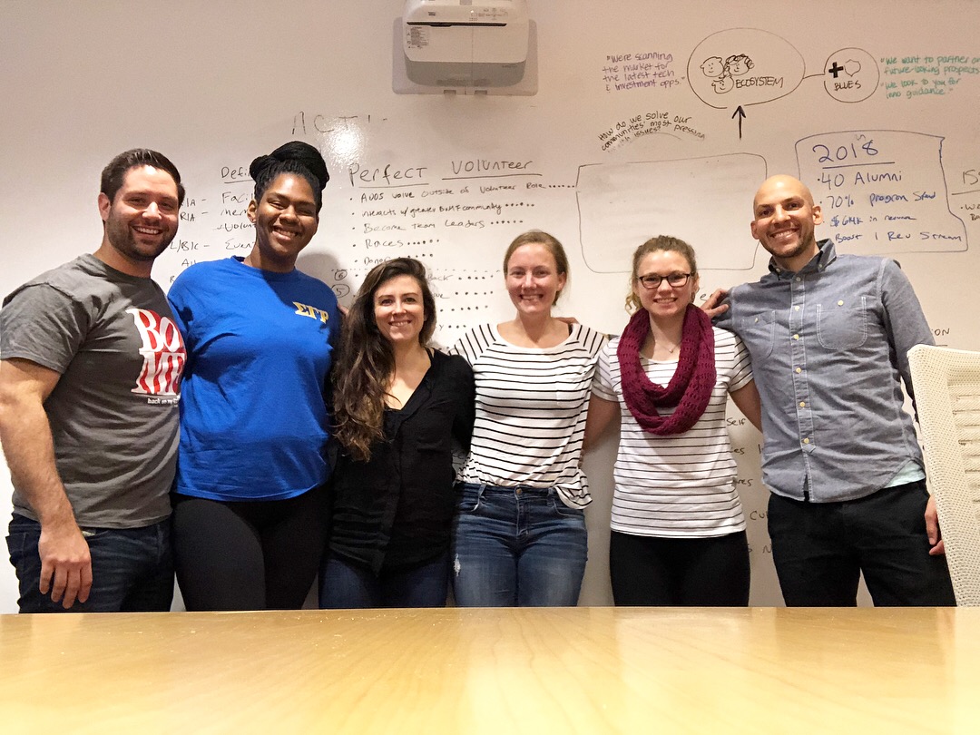 Griff, far right in a blue shirt, with a leadership team in front of a whiteboard