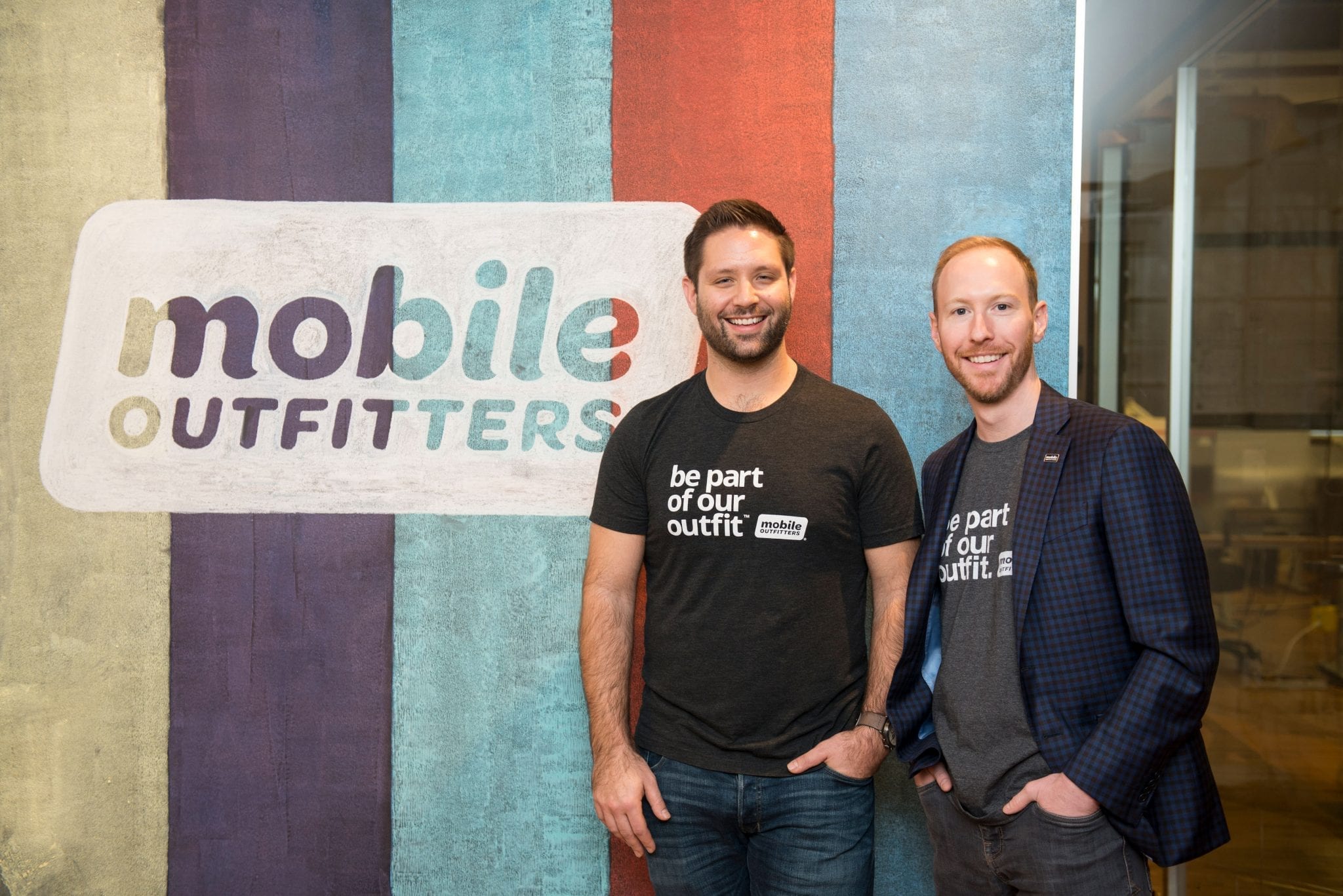 Griff and his Mobile Outfitters co-founder in front of the Mobile Outfitters logo